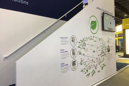 Tv on a  wall at an exibition, there are drawing on the wall